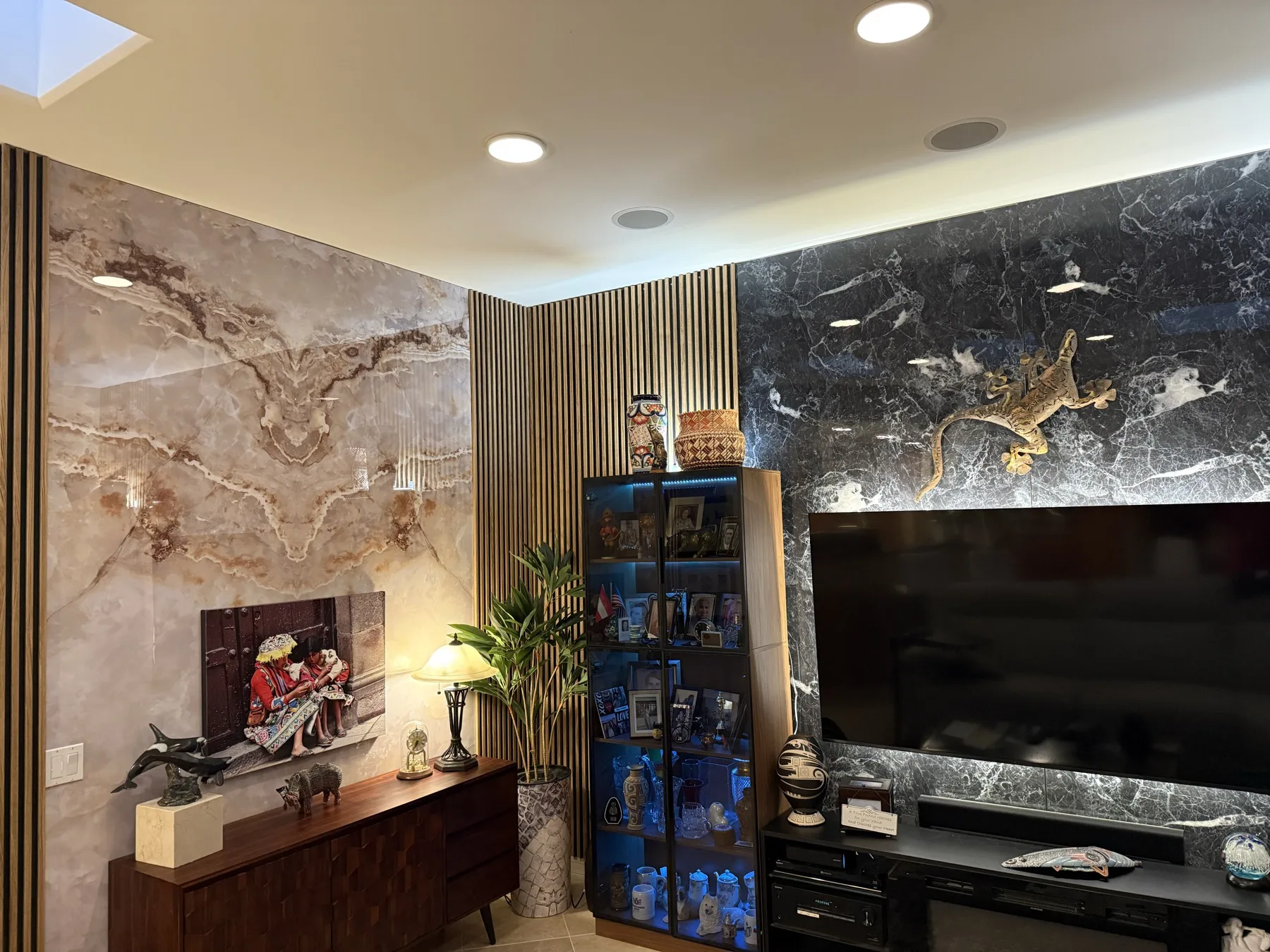 Real customer room combining Golden Ice Jade bookmatch marble, Obsidean White PVC marble, and acoustic slat panels