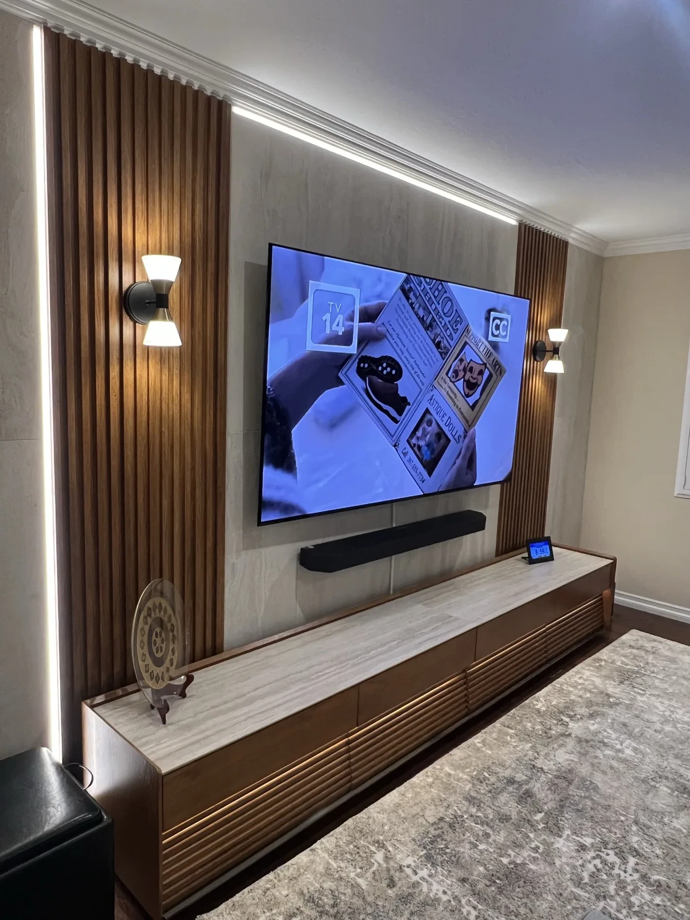 Angled view of a customer walnut fluted TV wall with illuminated panel details