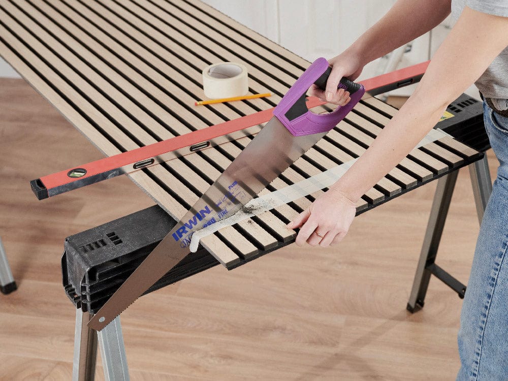 Step 3: Use a fine tooth saw to cut the panel along the marked line.