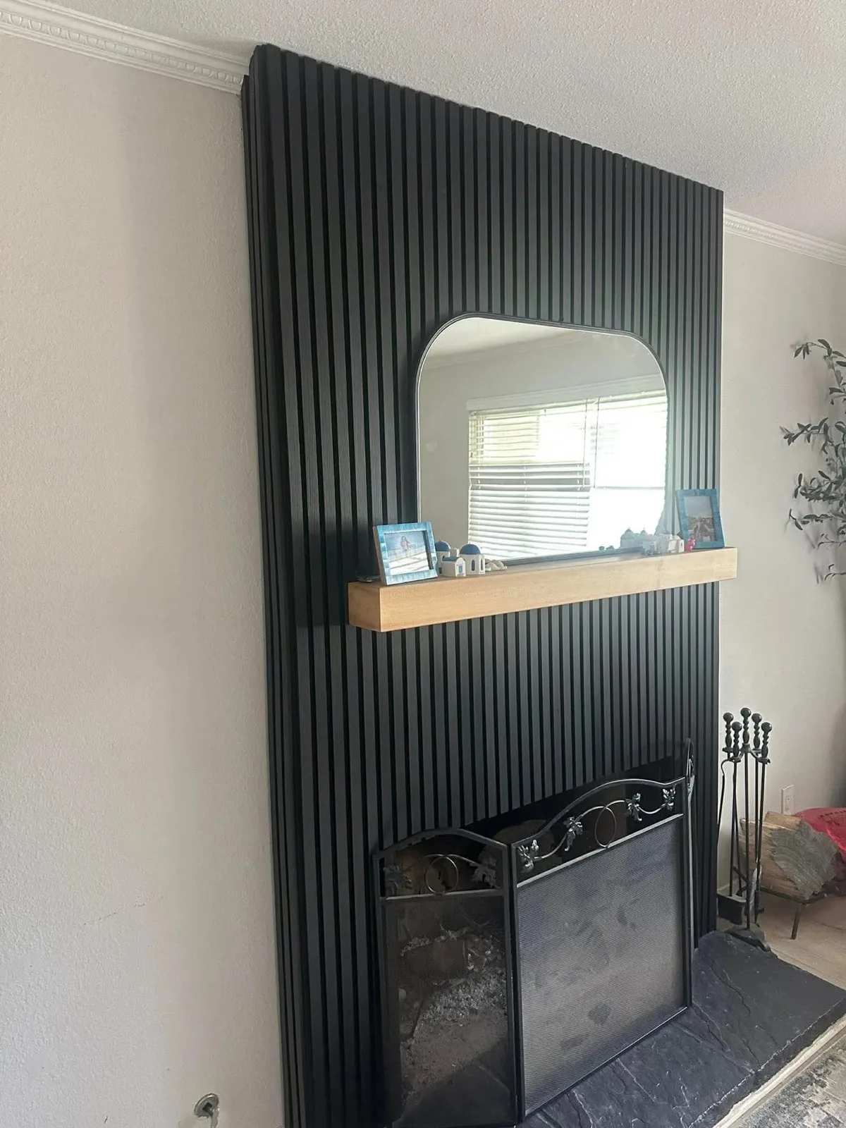 Black Oak 21 x 106 in acoustic slat panels installed around a customer fireplace and mirror