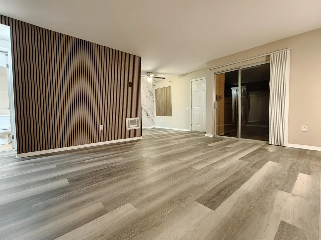 Wide customer living room with a full-height Gray Oak acoustic slat panel feature wall
