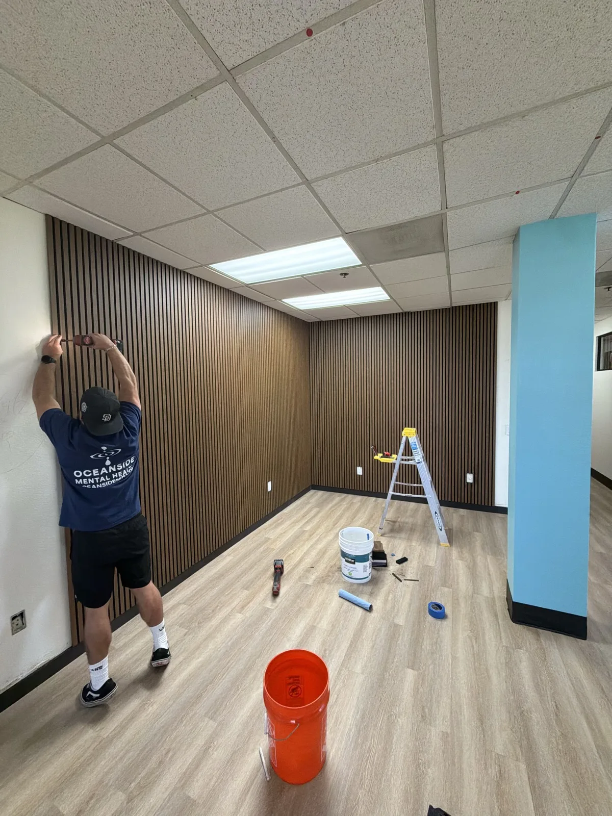 Walnut 21 x 106 in acoustic panels being installed around two office walls