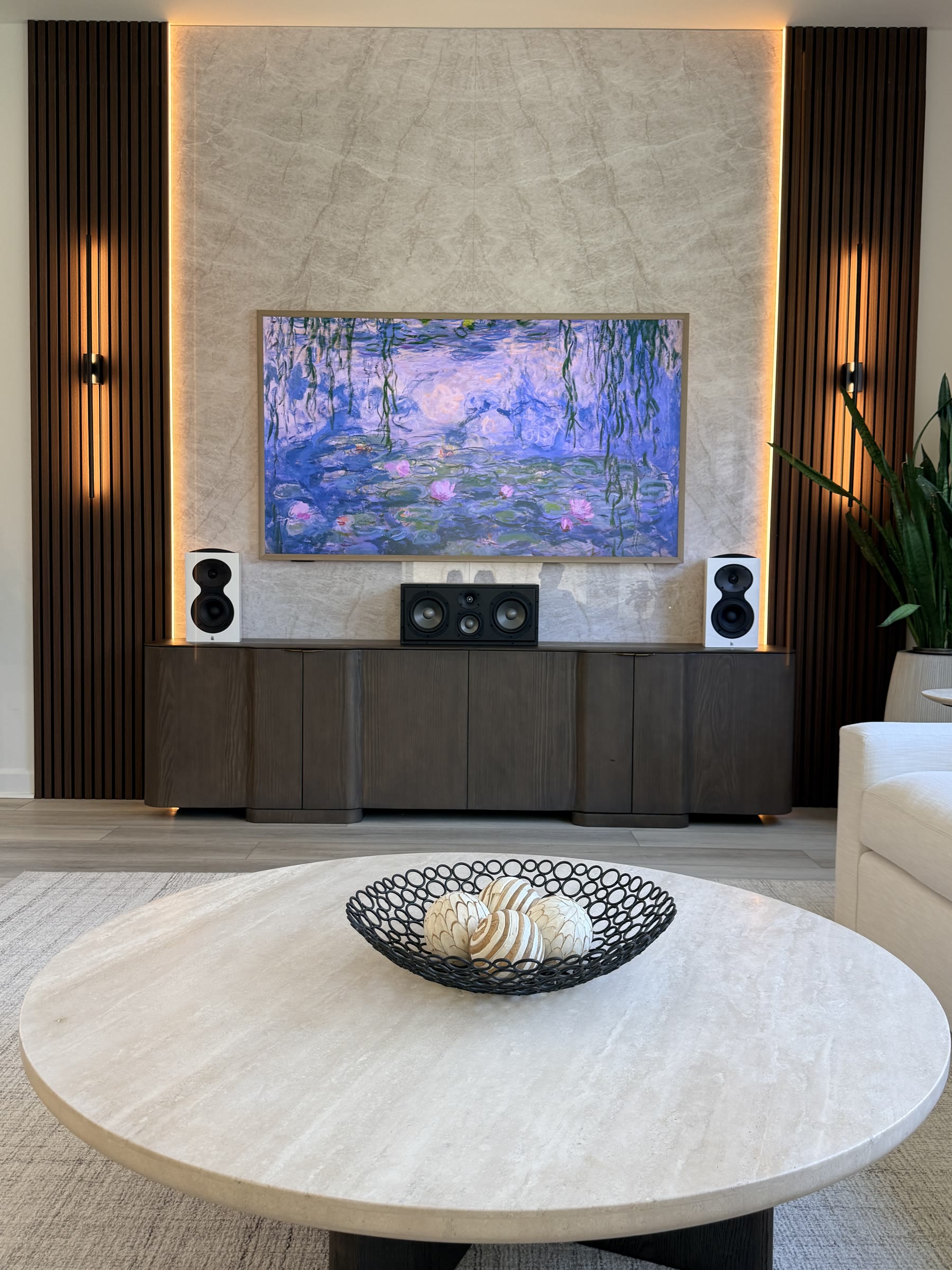 Taj Mahal bookmatch marble panel installed TV wall with warm accent lighting