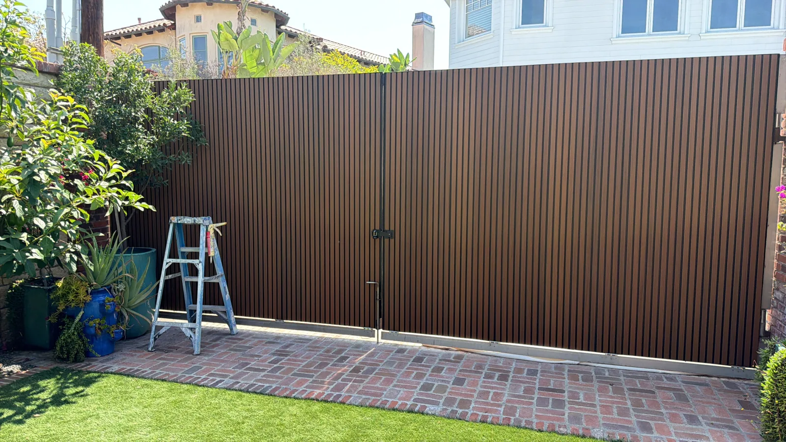 Customer driveway gate finished with teak exterior slat panels