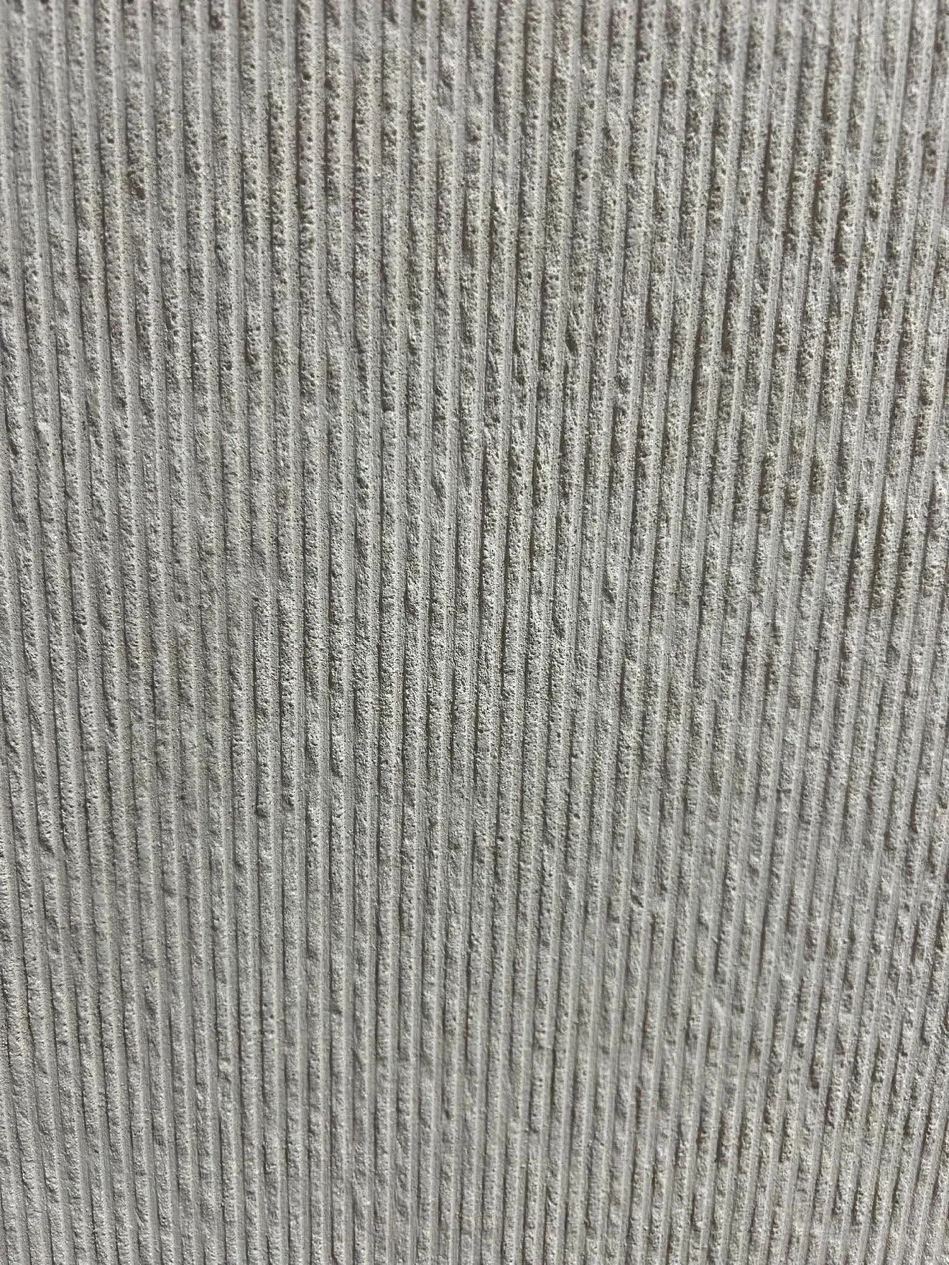 Vertical ribbed gray flexible stone wall surface