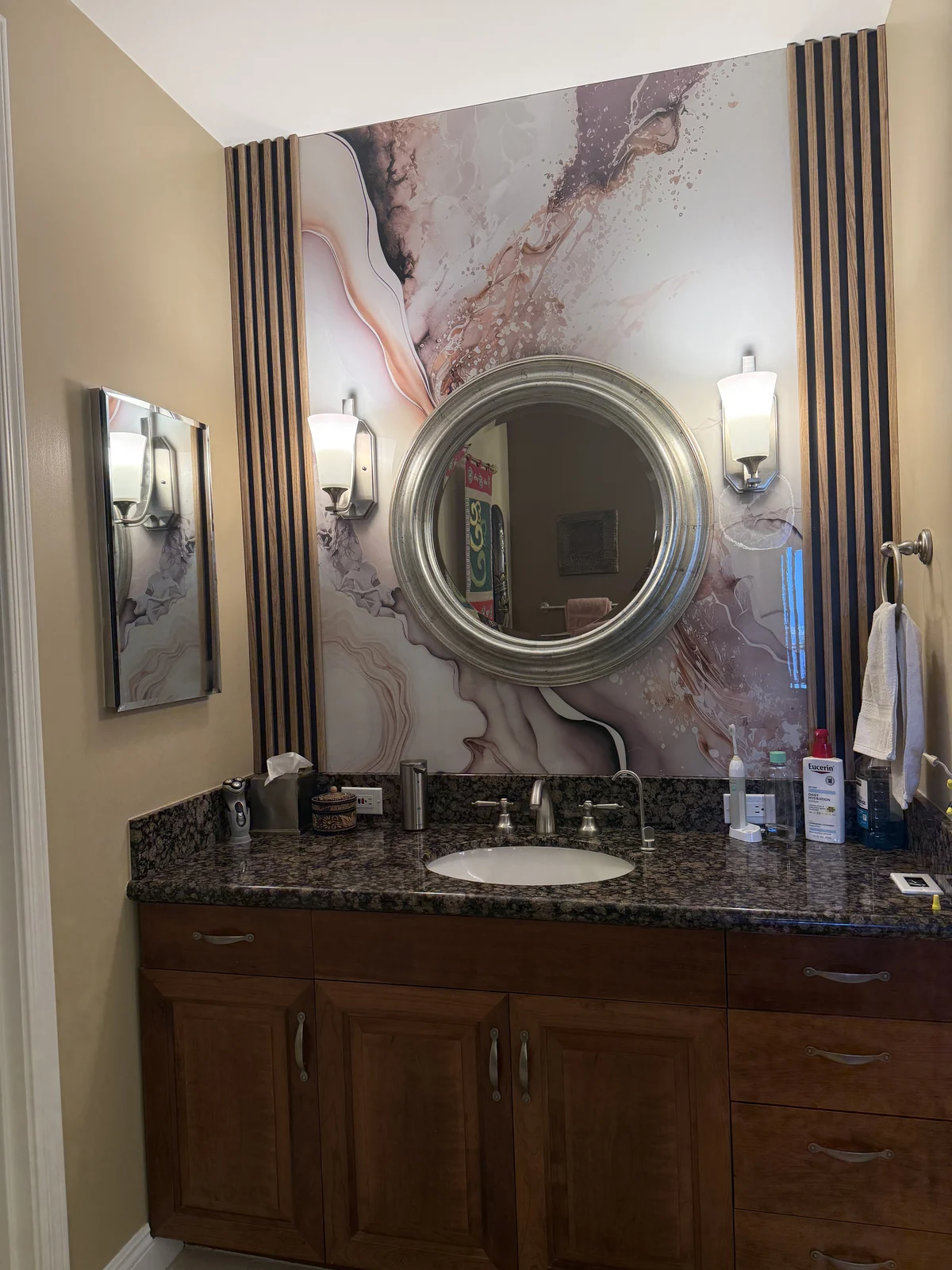 Yuliu Mountain PVC marble panels installed around a bathroom vanity and round mirror